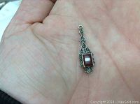 Pendant shown on palm to illustrate size - approximately 1 inch long. Shows front detail with carnelian stone and marcasite accents in silver setting.