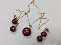 Large dyed natural pearl pendant and dyed pearl stud earrings on 14k gold filled chain shown on white background.