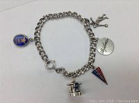 Sterling silver chain bracelet with attached school and themed charms including golfer and pennant flag.