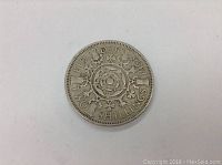 Close-up of obverse side of 1958 English 2 shilling coin showing floral rose design and inscriptions.