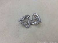 Front view of the sterling silver heart earrings with diamond accents shows their shape and details.