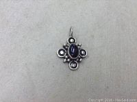 Front view of the sterling silver pendant showing the garnet centerpiece and decorative silver bead accents on a plain background.