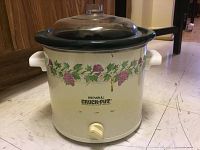 Front view of Rival Crock-Pot slow cooker with grapevine floral design, dial control, white body and glass lid.