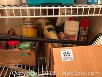 Shelf with box of light bulbs, Turtle Wax Zip Wax, Rust Check spray, cleaning mitts, small assorted household items