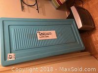 Photo showing blue plastic under-bed storage container with lid labeled 'Bedroom Under Bed'.