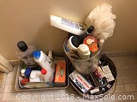 Photo of three assorted containers filled with toiletry items including shampoo, lotion, toothpaste, and a bath pouf