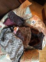 Overview of all gloves and scarves displayed on an upholstered chair showing the variety of leather gloves and scarves