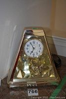 Full view of the Seiko pyramid-shaped anniversary style clock with white clock face and gold-tone frame