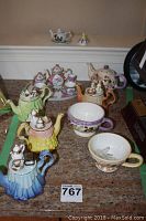 Full view of tea time decor assortment including Royal Albert mini decorative teapots, doll size tea cups, and miniature tea set on tray.