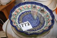 Large decorative scalloped ceramic bowl with floral design and two large clear light bulbs inside.