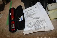 VuPoint Magic Wand III portable scanner in black zippered case, microSD card visible, with manual documentation.