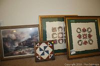 Four framed wall art pieces including two signed quilt motif prints by Judy Severson, a framed train print, and a small quilt block framed piece, arranged side by side.