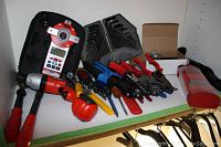 Lot contents showing variety of hand tools including locking pliers, screwdrivers, hex keys, and plastic parts box.