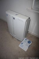 Sharp FP-P60CX white air purifier standing on carpet floor near wall and window.