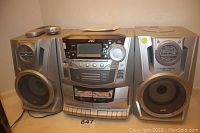 Main component system with central silver unit and matching left and right speakers, showing full front view