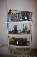 Full view of plastic shelving unit loaded with various tools and accessories including tool cases, hand tools, detailing items, boxes, and packaging.