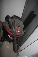 Front view of black and red Craftsman wet/dry vacuum with hose and attached accessories, showing general condition.