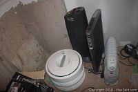 Photo showing a white Honeywell HEPA air filter, a black Ionic Breeze GP air purifier, a black SoleUSAir air filter, and a white DeLonghi Safeheat Solaris heater on the floor.