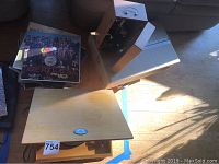 Wooden microscope case, stack of vinyl records, wooden-topped record player