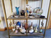 Shelf with assorted ceramic and porcelain figurines, dishes, decorative jars, and plates.