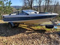 Port side view of the boat on the trailer parked outdoors.