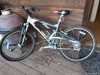 Full side view of the silver and black Schwinn mountain bike with suspension and red-accented saddle.