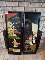 Full view of two vertical black wooden panels featuring Asian-themed hand-cut stone and jade artwork with hand-painted scenery and traditional figures.