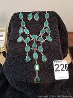 Full necklace set with matching earrings displayed on black fabric background