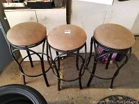 Photo of three beige suede seat bar stools with black metal swivel bases, showing front and side angles.