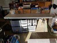 Full view of resin folding leg table with boxes and items placed on top, showing overall item and usage context.