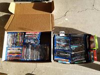 Two open boxes filled with Blu-ray movies showing many titles arranged side by side in cases.