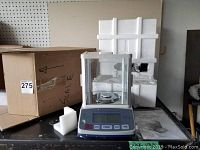 Scale and packaging arranged on table, showing the unit with its original box and styrofoam inserts