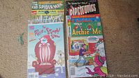 Photo showing a variety of vintage comic books including Spider-Man Annual, Mutants, Ren and Stimpy Show, Archie, and Electronics story by Archie Comics.