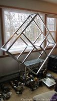 Full view of chrome geometric etagere in front of window