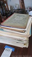 Stack of assorted sheet music and lesson books showing variety and volume.