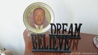 Photo of the Dr. Martin Luther King Jr. collectible plate with wooden cutout words 'BELIEVE' and 'DREAM' placed on a surface