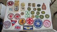 Top view of assortment of Boy Scout and related patches along with a metal compass
