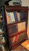 Three-stack wood and glass Barrister bookcase filled with books