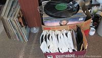 Box containing approximately 40+ vinyl records in cardboard sleeves and paper inner sleeves