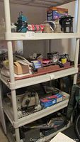 Shelving unit with various tools and kits, including power tools and boxes