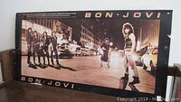 Bon Jovi poster featuring band members on street at night with black border