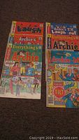 Photo of 8 Archie-related comic books on a carpeted floor, featuring Laugh, Archie’s TV Laugh-Out, Everything's Archie and Archie-Me titles.