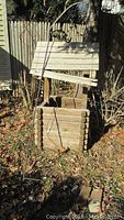 Wooden wishing well planter with roof outdoors, showing condition and size.