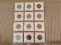 Full set of 12 Canadian 1992 provincial quarters shown in white cardboard holders with province names and years handwritten in red ink.