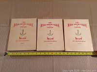 Three hardcover 1952, 1953, and 1954 Royal Military College of Canada Review yearbooks laid side by side on a surface with a measuring tape showing approx 12 inches in width.