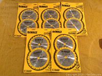 Overview photo showing all five packs of DeWalt cutting blades on a yellow towel background, each pack containing two blades for a total of 10 blades.