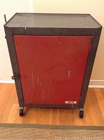 Front view of red door closed with visible surface wear, Delta badge on lower right corner.