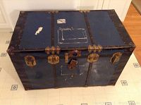 Front and top view of the blue metal trunk showing locks, hardware and top panel with missing key lock