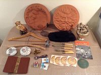 Top view of all miscellaneous items on table including ceramic wall hangings, knives, fur muff, coasters etc.