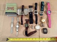 All 12 wristwatches laid out on surface showing variety of styles, bands, and colors
